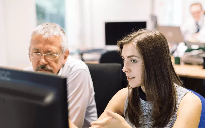 man and woman at computer screen