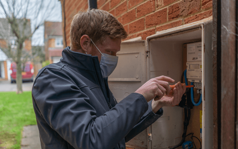 An image showing an SMS engineer installing a smart meter