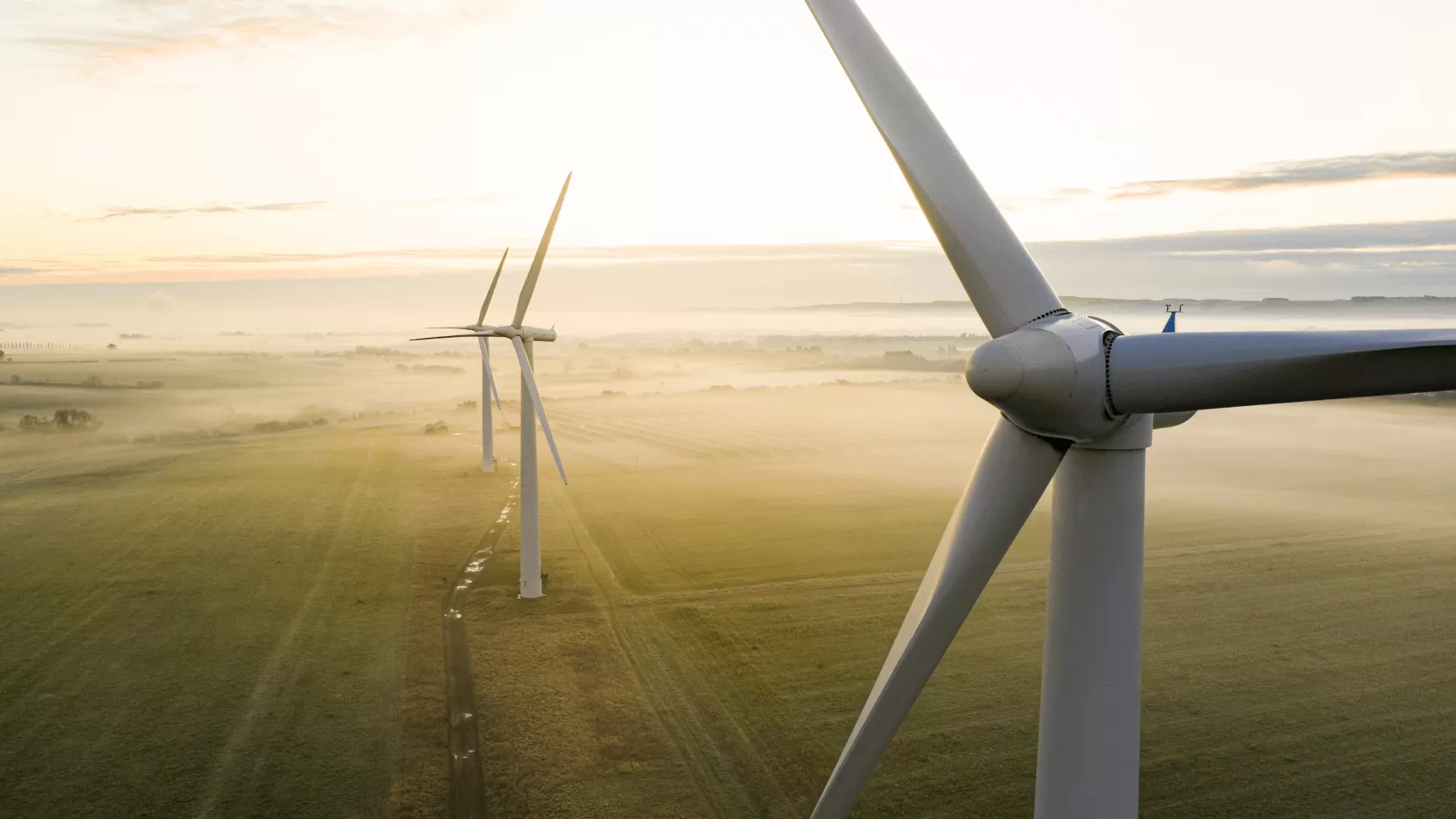 large windmills on foggy field