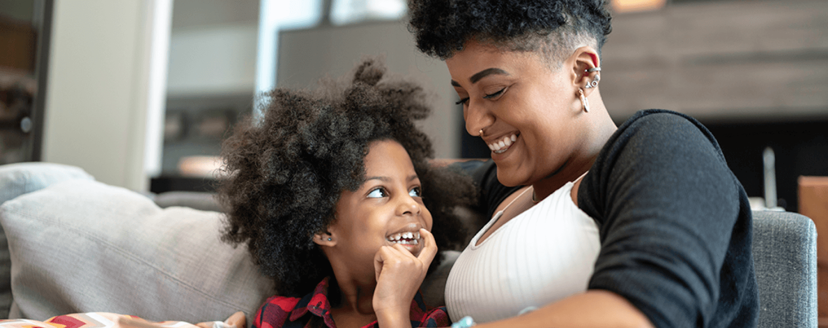 Woman and child sitting on sofa laughing