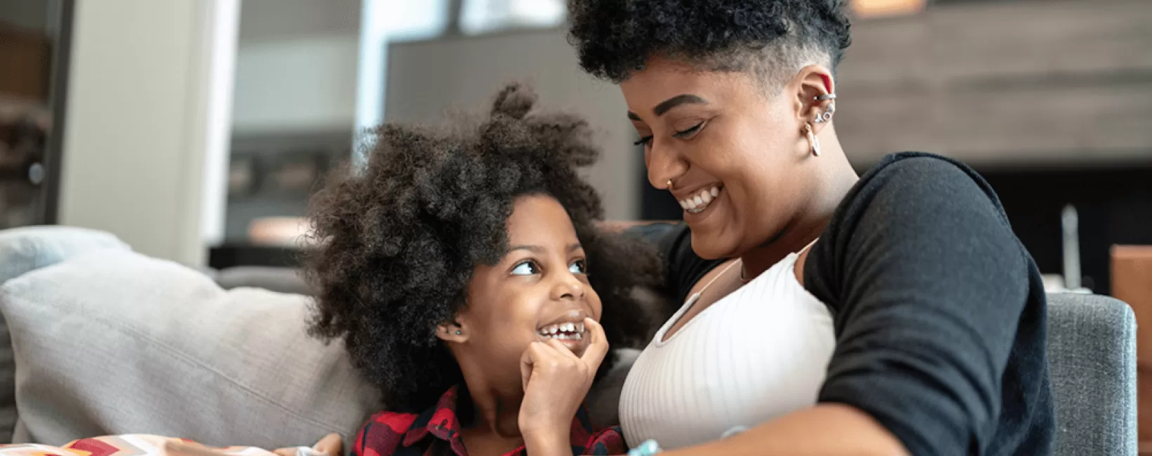 Woman and child sitting on sofa laughing