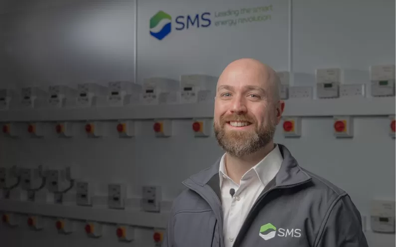 image showing an SMS employee in front of smart meters
